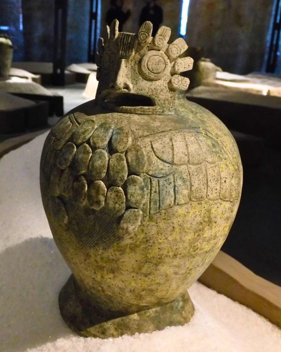 4 of 5, a ceramic vase in the shape of a bird, sits on salt within a platform on the ground